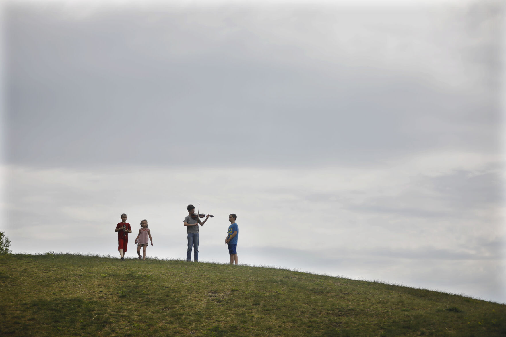 evan miller plays violin on hill with other kids